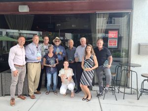 Group of people holding awards outside a restaurant